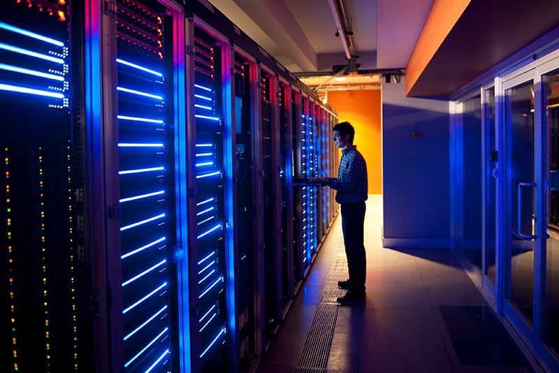 Een man in een datacenter edie de virtuele infrastructuur van een bedrijf beheert